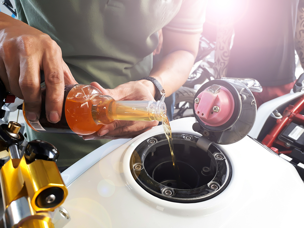 Close up hand holding oil bottle, bigbike maintenance work