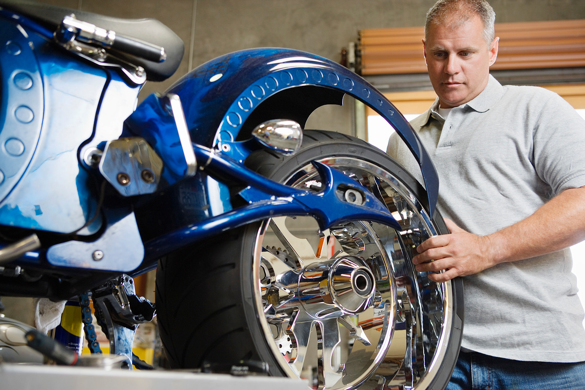 Mid-adult mechanic repairing motorcycle